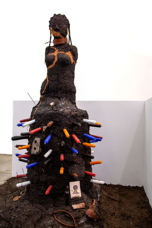 Sculpture of a body made with dirt.