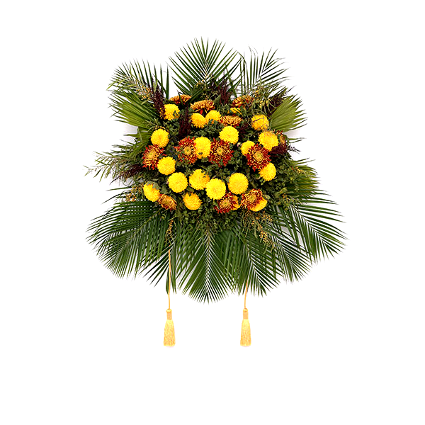 A bouquet that includes round yellow and rust-colored flowers in the center, surrounded all around by green palm fronds, and two yellow cords ending in tassels hanging below.