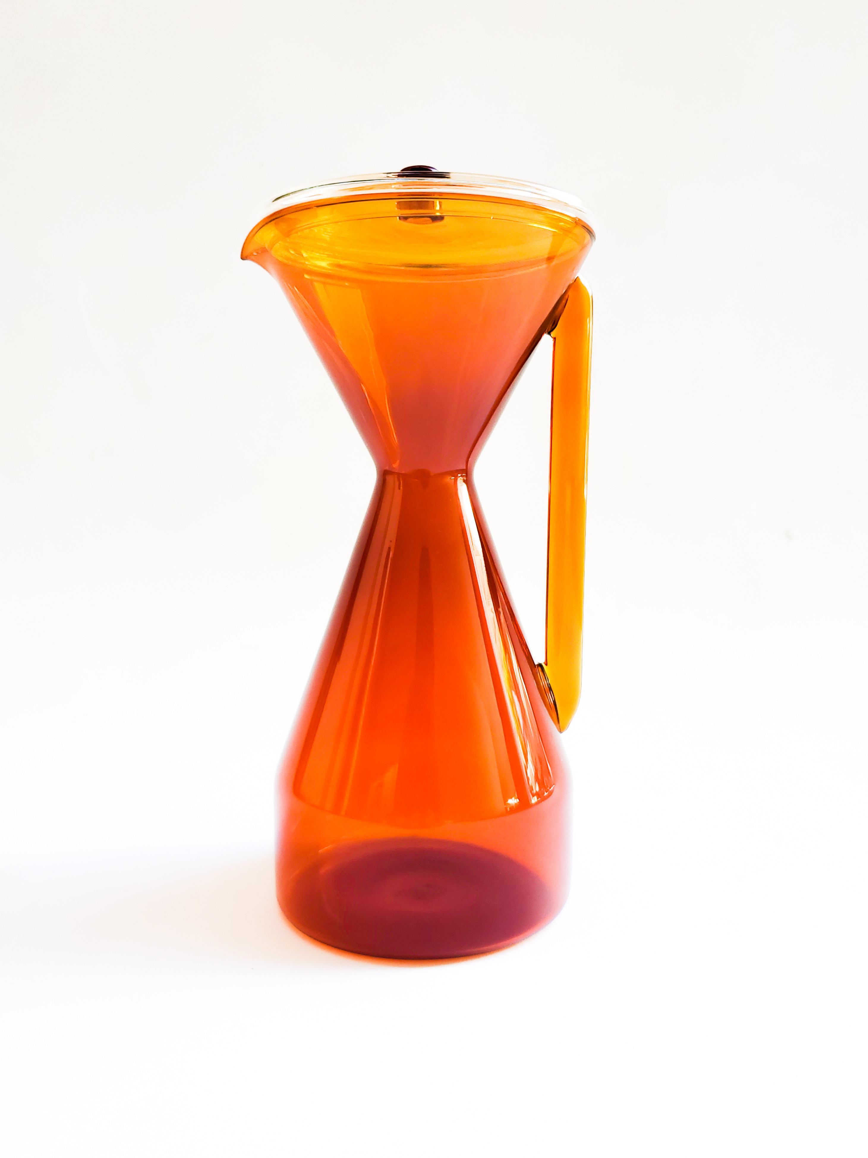 Orange, glass, tall, hourglass-shaped carafe. 