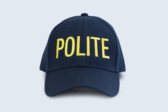 A navy hat with the word POLITE in yellow letters