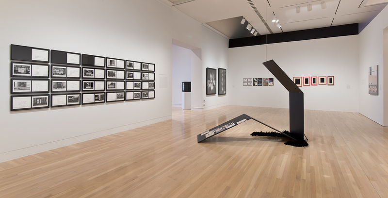 Center, on floor: Tom Burr, "Propped Perfume," 2008; left wall, from left to right: Martha Rosler, "The Bowery in two inadequate descriptive systems," 1974–75, two works by Allan McCollum titled "Perpetual Photo," 1982; rear wall, from left to right: Silvia Kolbowski, "Model Pleasure III," 1983, and Allan McCollum, "Collection of Five Plaster Surrogates," 1982/1990; right wall: Louise Lawler, "Bulbs," 2005–6. Installation view at the Hammer Museum, Los Angeles