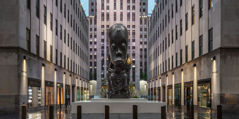 A large sculpture of a seated figure installed outside Rockefeller Center in New York City