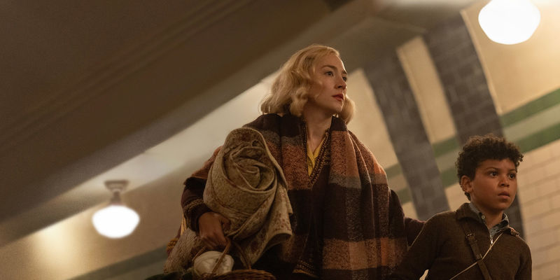 Saoirse Ronan & Elliott Heffernan walk together, holding a picnic basket and blanket