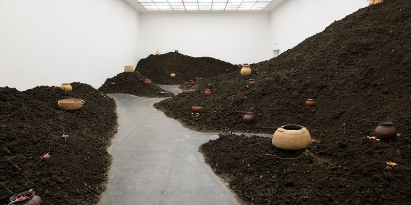 Art installation: A gallery filled with piled up soil studded with clay pots