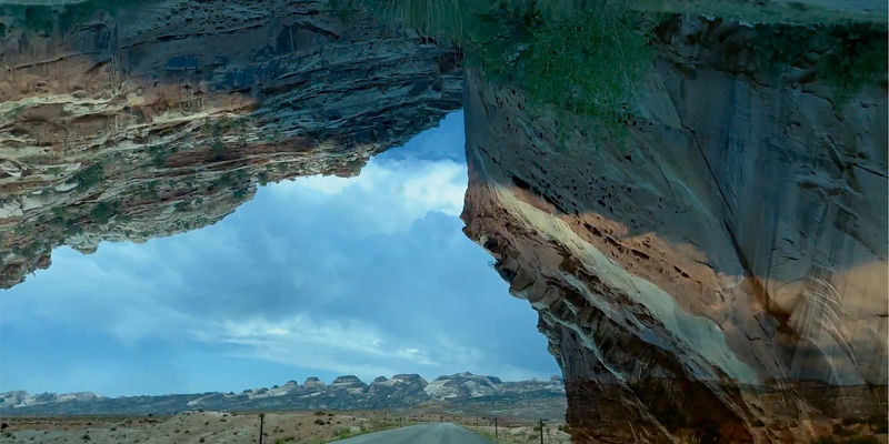 A composite landscape with a remote highway and a large rock formation
