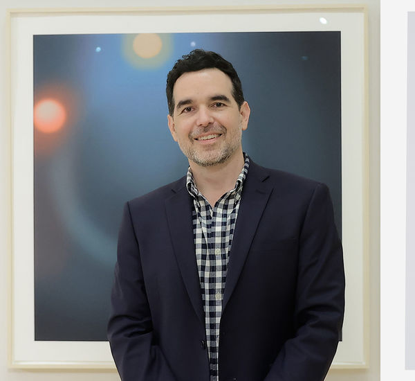 Headshot of Dario Robleto alongside an artwork