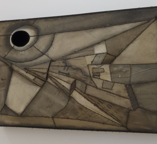 an abstract artwork hanging on a white wall