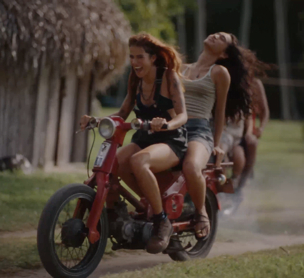 image of two people with long hair riding motorcycle