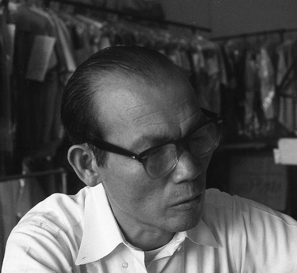 Black and white still of a man in a dry cleaning business