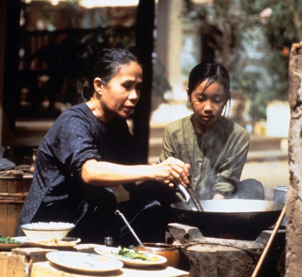 mother and daughter cooking outside