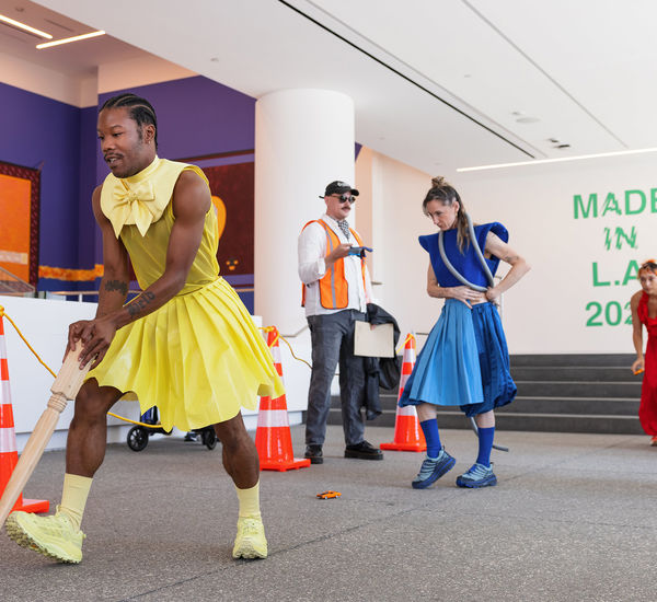 Brightly dressed dancers in the lobby of the Hammer Museum