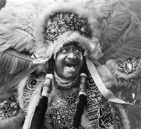 A man in an ornate beaded headdress and costume