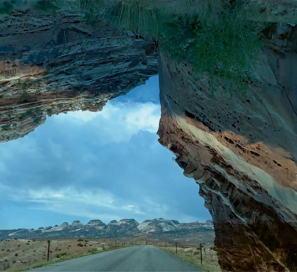 A composite landscape with a remote highway and a large rock formation