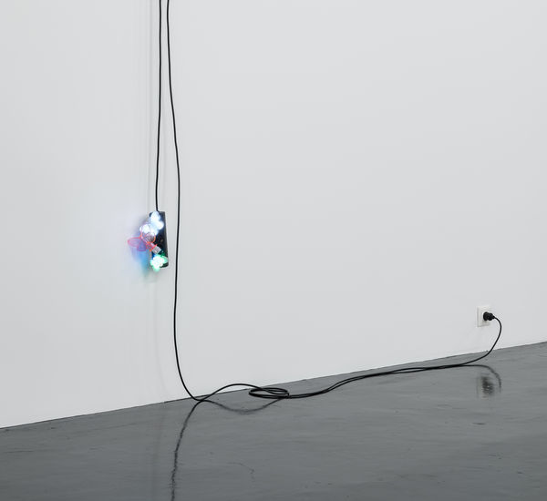 A black extension cord hangs from a wall, with three butterfly nightlights plugged into it