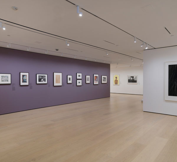 Gallery with framed works on paper mounted on the wall