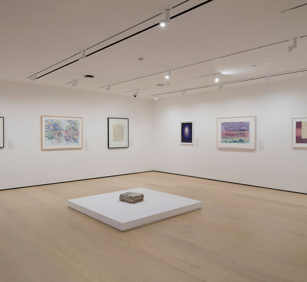 Gallery with works on paper installed on the wall and on a plinth