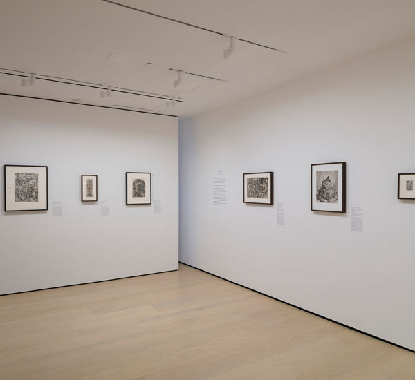 Gallery with framed works on paper mounted on the wall