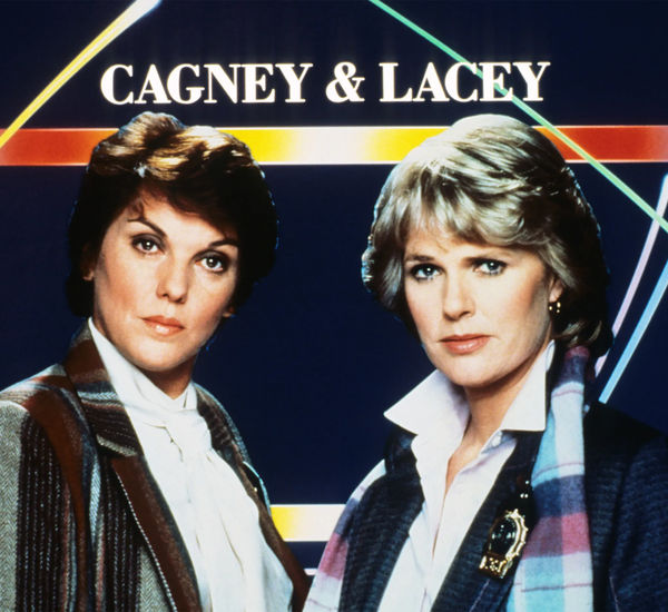 Two women with short hair stand in front of a graphic background reading CAGNEY & LACEY