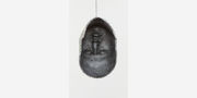 The artist's face, upside down and encircled by jewels