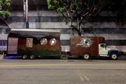 A decorated camper hitched to a box truck