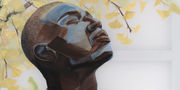 Expressive painting of a Black man, face turned toward the sun, in front of a gingko tree with yellow leaves