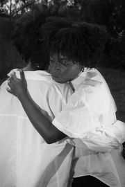 Two Black woman embrace each other