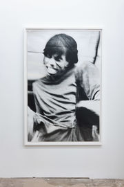 A figure with long bangs smiles wide, the image blurred as if from motion