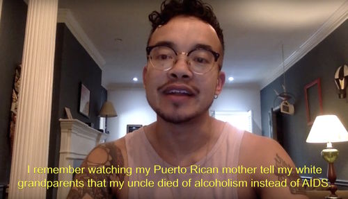 A man with glasses looks directly into a camera