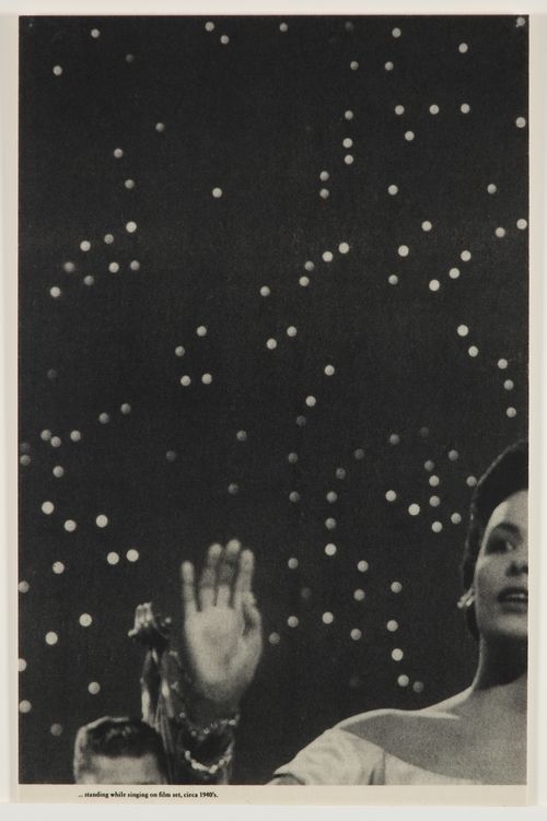 Half of a woman's face, with her hand lifted, on a background of stars