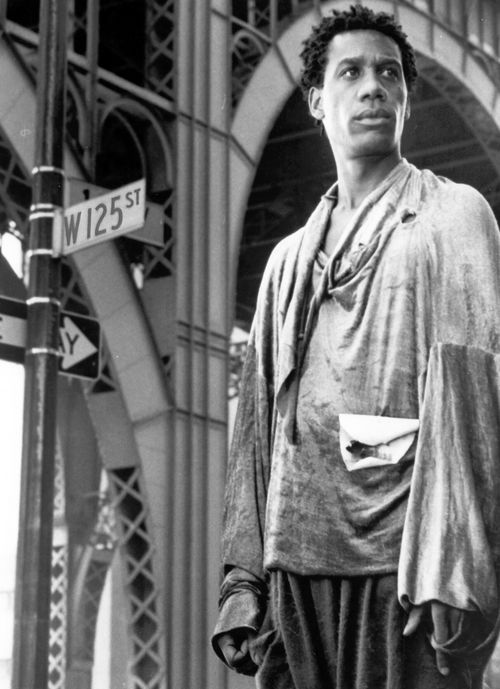 Detail of a still from the film The Brother From Another Planet (1984) showing a man standing in front of a W 125th Street sign in New York