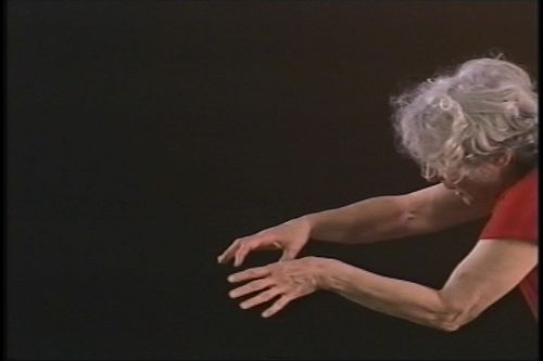 A woman leans into frame with her arms outstretched