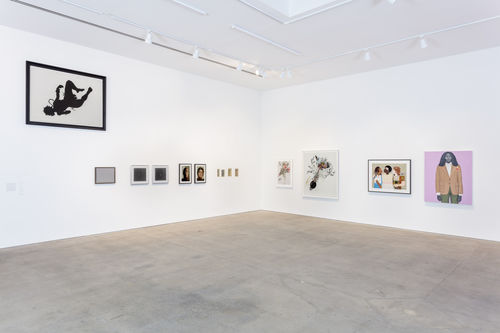 A white-walled gallery with several works hanging