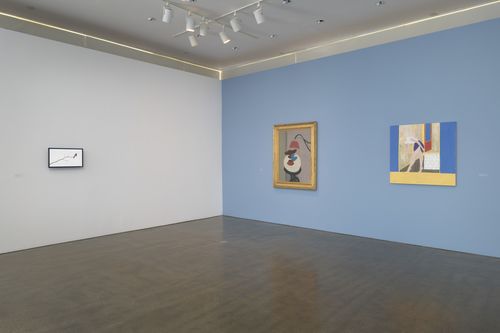 Two gallery walls, one white and one blue, with artworks hanging on them