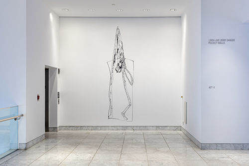 A vestibule, with a tall white wall covered with a thin black figure