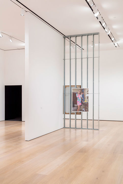 A museum gallery with a photograph hanging on an exposed wall