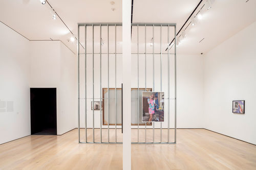 A museum gallery with a photograph hanging on an exposed wall