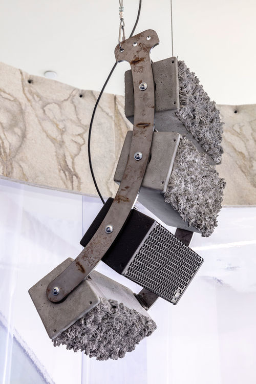 A curved set of four speakers suspended from the ceiling