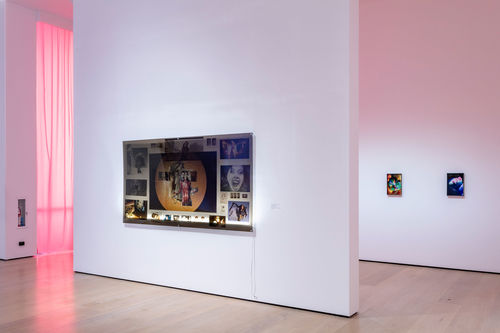 A gallery with a lightbox collage hanging on the wall