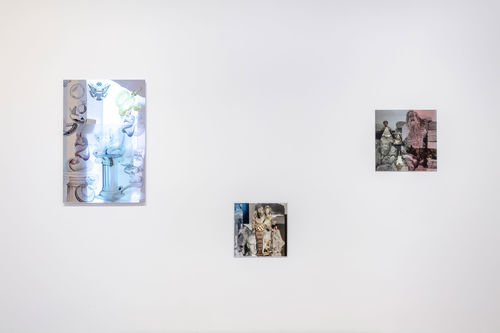 A white wall with reflective collages hanging on it