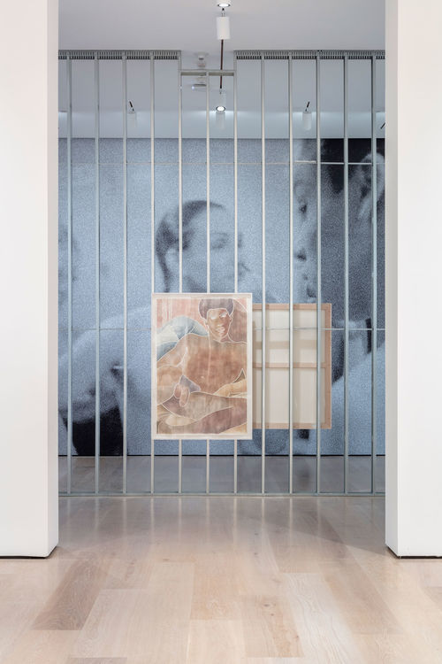 An exposed wall in a gallery with a large woodcut of a man hanging on it