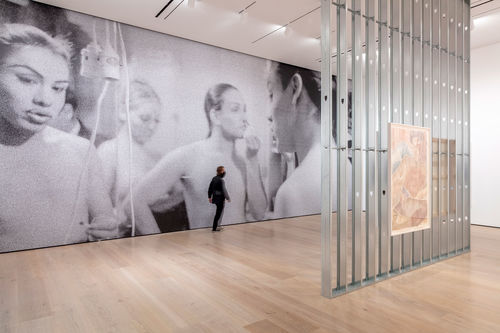 An exposed wall in a gallery with a large woodcut of a man hanging on it
