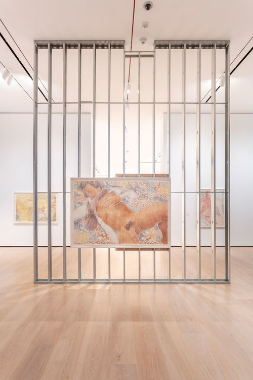 An exposed wall in a gallery with a large woodcut of a man hanging on it