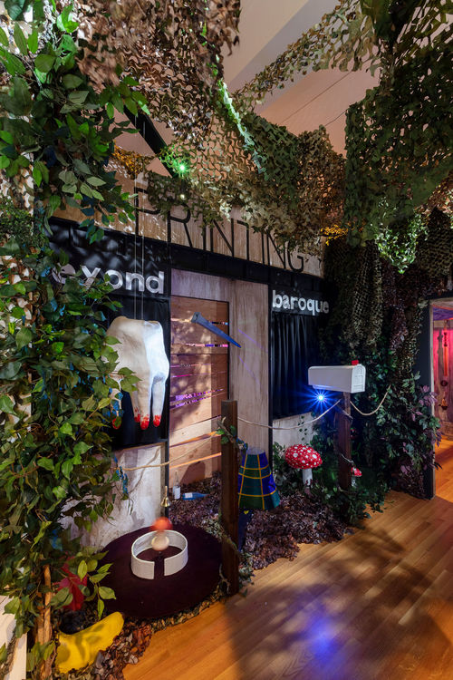 A large tooth hangs among some ivy at the entrance to a haunted house