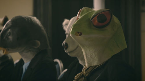 Image of two people wearing hoods over their heads that depict a bear and another animal.