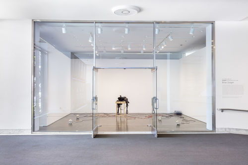 Room with glass wall and door filled with inanimate objects