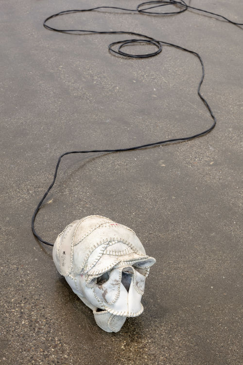 Wire connected to skull made of old baseball leather