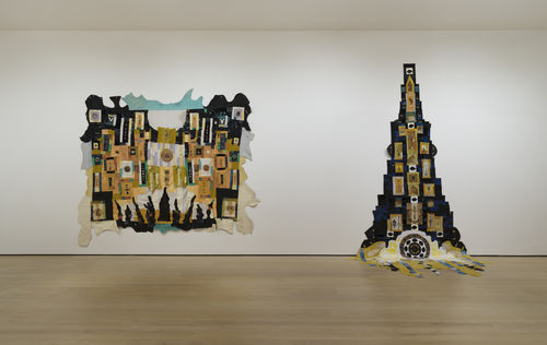 Two large quilts hung next to each other on a wall.