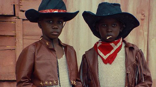Two young black boys wearing cowboy hats and leather jackets looking directly at the camera