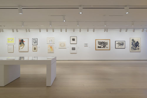 Gallery space with works on paper on the walls. 