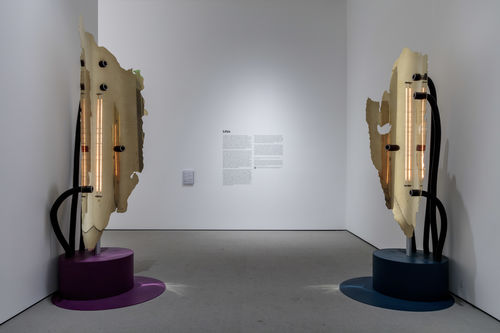 Gallery space with 2 tall sculptures.